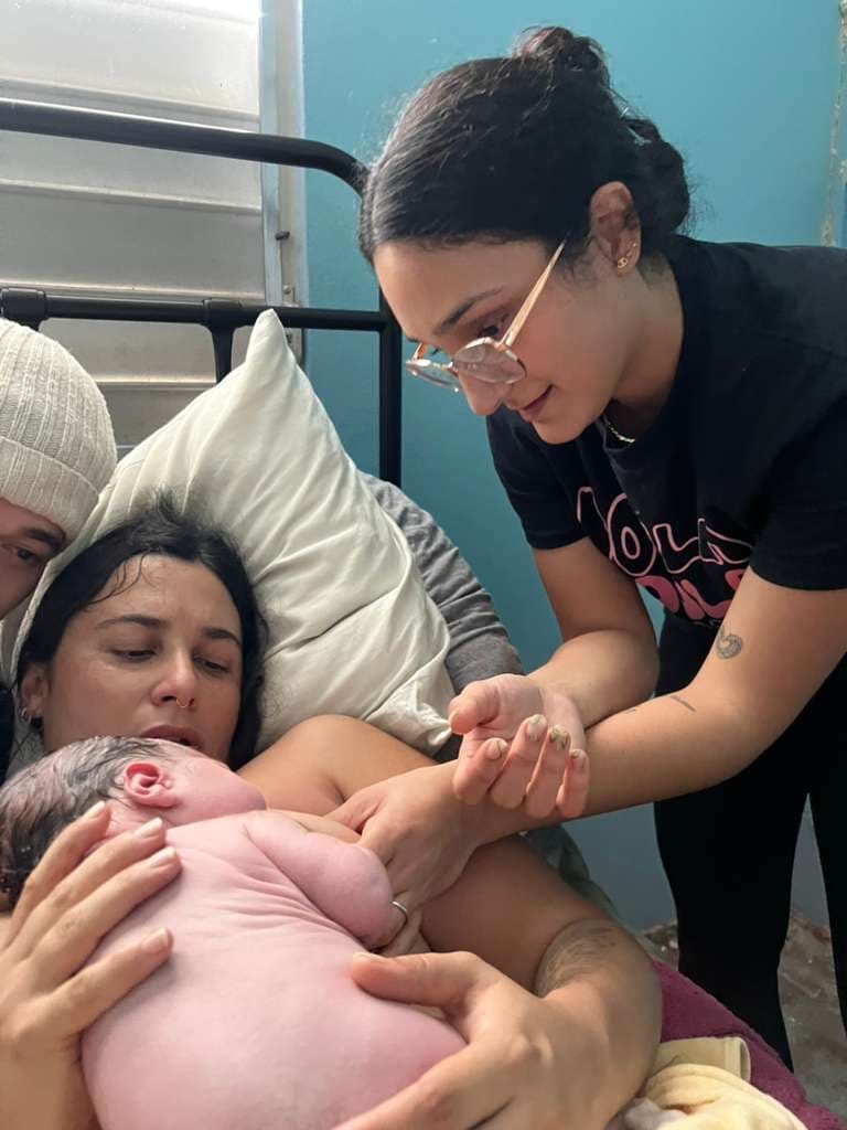 Charlotte supporting a parent as they hold their newborn after birth