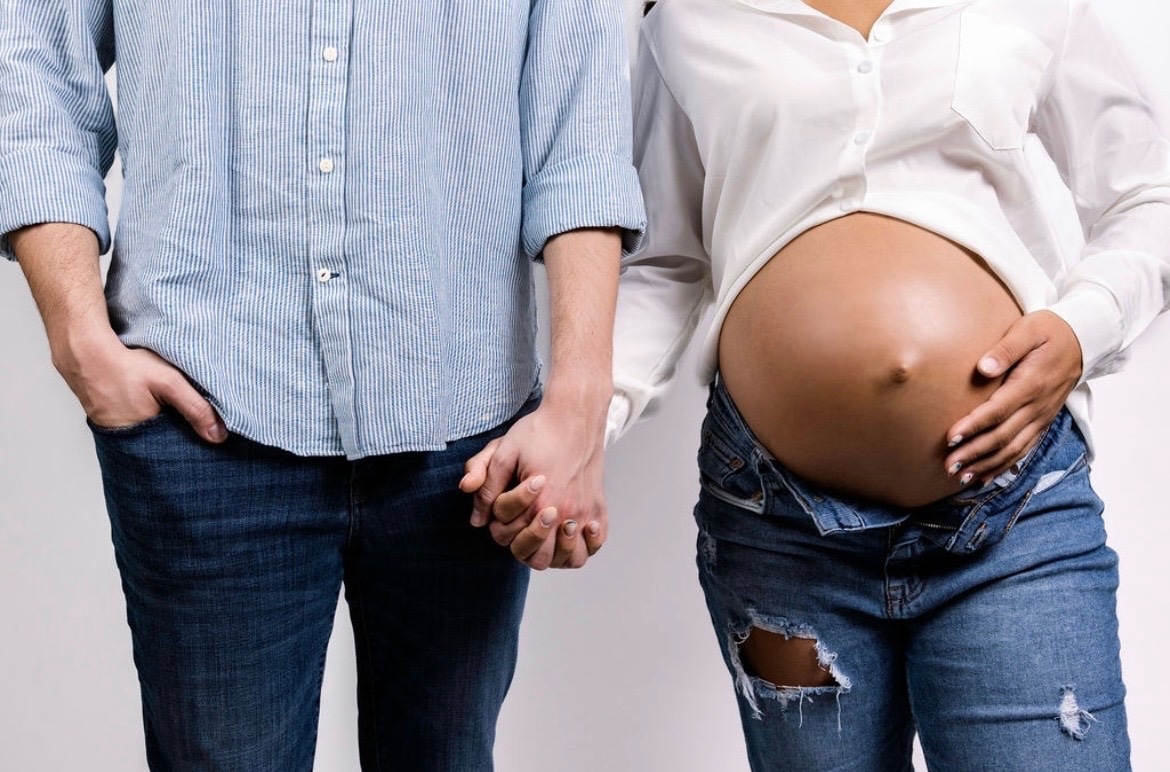 Expectant parents holding hands
